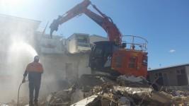 3 Storey Apartment Complex Demolition Large excavator demolishing a small building with Urban Demolition staff watching on