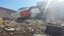 3 Storey Apartment Complex Demolition Large excavator demolishing a building